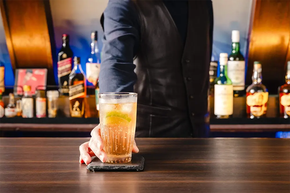 カウンターでドリンクを提供するオーナー